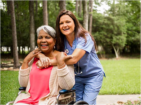 Happy woman in wheelchair with health care provider